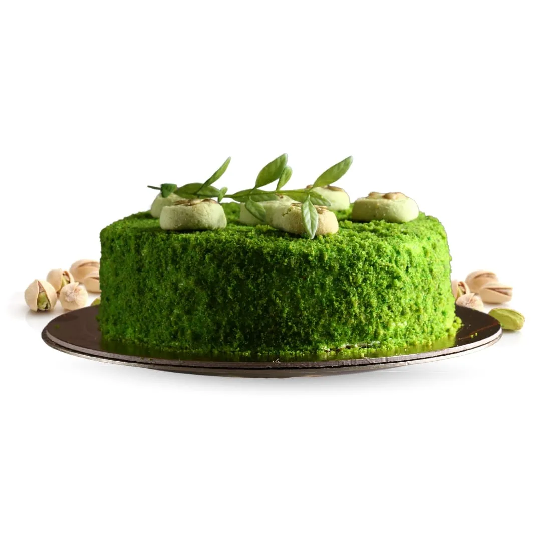 a green cake with nuts on top